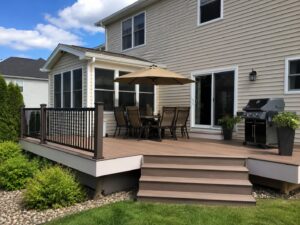 Raised backyard deck with outdoor dining area and grill